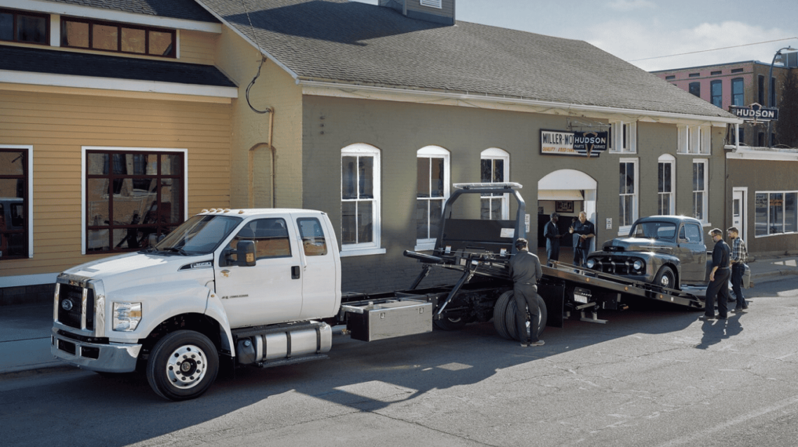 Ford work trucks towing a vehicle