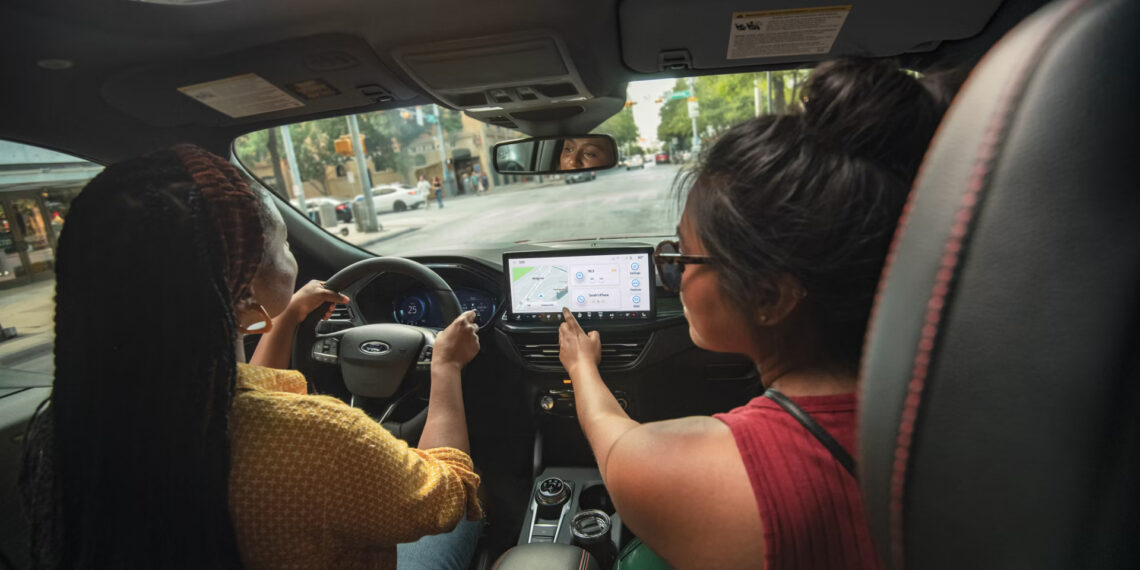 2026 Ford Escape PHEV interior with a driver and passenger.
