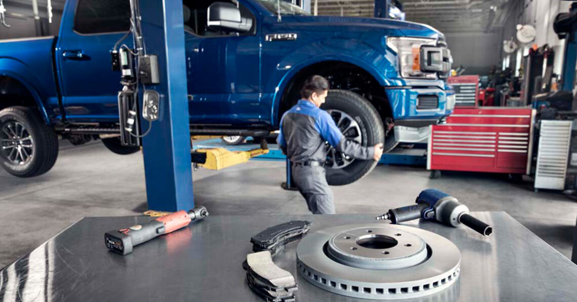 Ford service technician working on truck brakes.