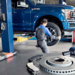 Ford service technician working on truck brakes.